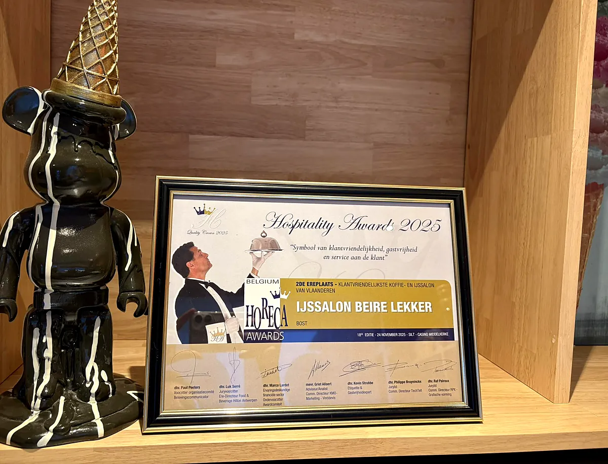 Het certificaat van de Hospitality Awards 2025 naast een zwart beeldje van een beer met een gouden hoorntje
